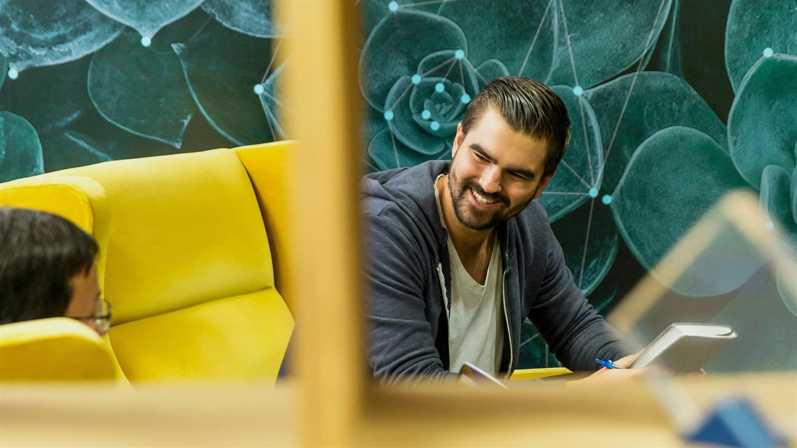 Photo of two colleagues engaged in a joyful conversation in a modern office space informal meeting area